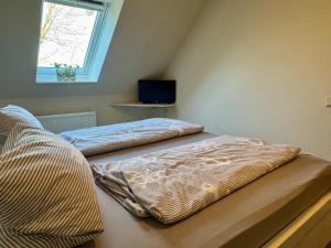 two beds in a room with a window at Ferienwohnung Petersen in Nordstrand