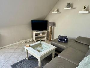 a living room with a couch and a tv at Ferienwohnung Petersen in Nordstrand +13 photos