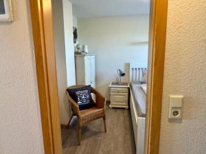 a bedroom with a chair with a pillow on it at Ferienwohnung Petersen in Nordstrand