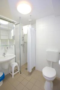 y baño con aseo, lavabo y ducha. en Study K & M Hotel en Debrecen