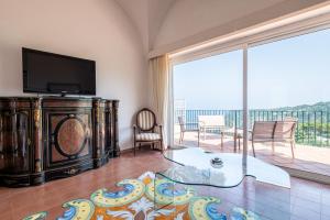 a living room with a tv and a large window at Tra Cielo e Mare & La Dépendance - Fantastic Sea View in Anacapri