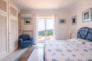 a bedroom with a bed and a blue chair at Tra Cielo e Mare & La Dépendance - Fantastic Sea View in Anacapri
