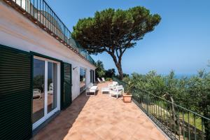 a balcony with chairs and a tree on a house at Tra Cielo e Mare & La Dépendance - Fantastic Sea View in Anacapri