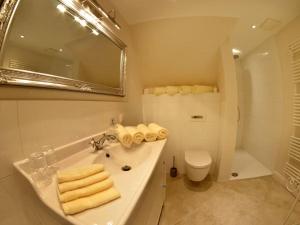 a bathroom with a sink and a toilet and a mirror at MR Landhaus Uhlenhof 5 in Groß Zicker