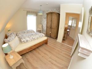 a bedroom with a bed and a wooden floor at MR Landhaus Uhlenhof 5 in Groß Zicker