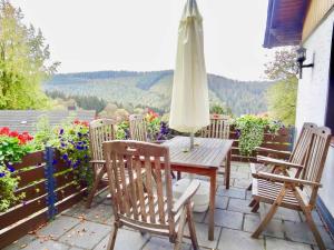 a wooden table with chairs and an umbrella on a patio at Schöne Aussicht am Eifelsteig in Monschau
