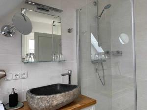 a bathroom with a sink and a glass shower at Haus Lindenstraße 3 in Beckdorf