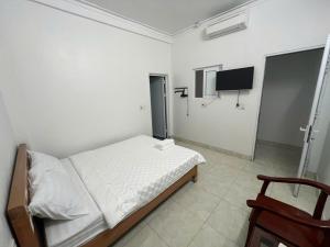 a bedroom with a bed and a flat screen tv at Thanh Thao Hostel - HaGiang Loop Tour in Làng Lap