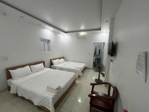 a bedroom with two beds and a television in it at Thanh Thao Hostel - HaGiang Loop Tour in Làng Lap