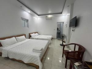 a bedroom with two beds and a flat screen tv at Thanh Thao Hostel - HaGiang Loop Tour in Làng Lap