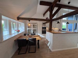 a kitchen and dining room with a wooden table and chairs at Ferien unterm Reetdach in Stade