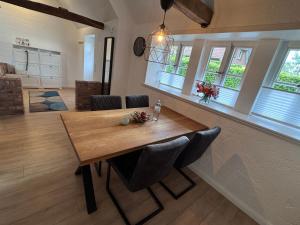a dining room with a wooden table and chairs at Ferien unterm Reetdach in Stade