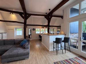 a living room with a couch and a kitchen at Ferien unterm Reetdach in Stade +6 photos