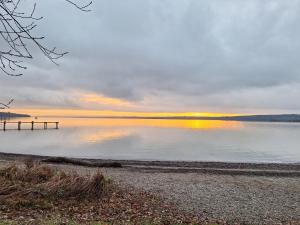 a sunset over a lake with a pier at Ferienwohnung Demmelbach in Weil