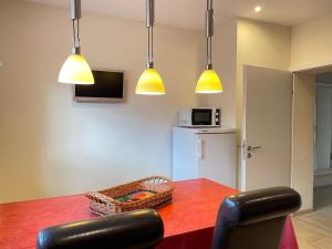 a dining room with a red table and yellow lights at Zimmer & Ferienwohnung Steuer in Leippe