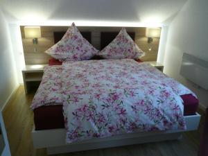 a bedroom with a large bed with pink flowers at Die Wohlfühloase in Frankenau
