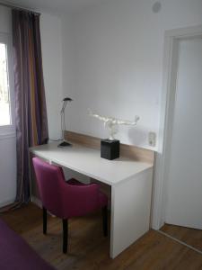 a white desk with a purple chair and a lamp at Die Wohlfühloase in Frankenau