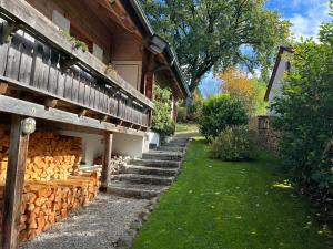 a path next to a house with a pile of logs at Ferienwohnung Kugler in Grafrath