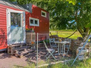 a red house with a table and chairs outside at Tiny House auf der Alpaka Farm in Rubkow