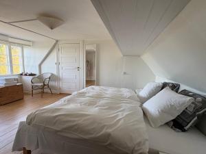 a bedroom with a large white bed in a room at Købmandsgården, Ballen in Ballen