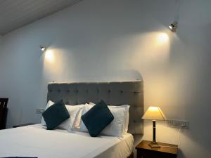 a bedroom with a white bed with a lamp and a bed sidx sidx at DD cottages Mandrem Goa in Mandrem