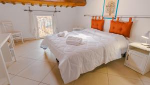 a bedroom with a bed with white sheets and orange pillows at Domus Dantis - Italian Homing in Ravenna