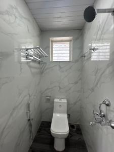 a bathroom with a white toilet and a window at DD cottages Mandrem Goa in Mandrem +4 photos