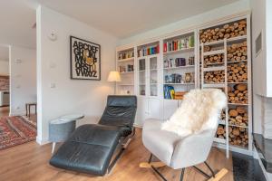 a living room with two chairs and a book shelf at Ferienhaus DeRuhHus in Rankwitz
