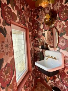 a bathroom with a sink and floral wallpaper at Bienvenue au 24 in Le Havre +46 photos