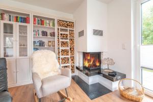 a living room with a fireplace and a chair at Ferienhaus DeRuhHus in Rankwitz +76 photos
