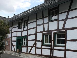 a black and white building with a green door at Rurtalgarten in Hammer