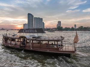 Un barco en el agua con un cartel. en Chatrium Hotel Riverside Bangkok en Bangkok