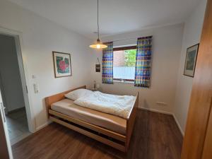 a bedroom with a bed and a window at Haus Gartenglück in Barßel