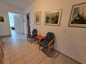 a waiting room with three chairs and a table at Haus Gartenglück in Barßel