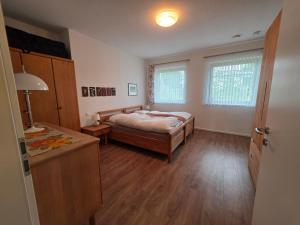 a bedroom with a bed and a table in it at Haus Gartenglück in Barßel +14 photos