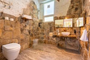a stone bathroom with a toilet and a sink at Seclude Ramgarh Cliff's edge in Rāmgarh +154 photos