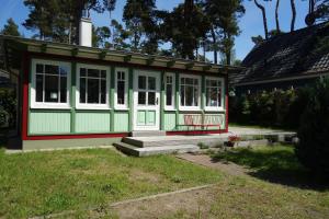 a small green and white house with a porch at Ferienhaus Kienhus in Graal-Müritz
