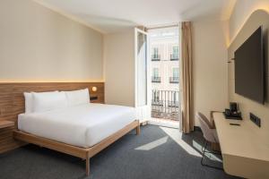 a hotel room with a bed and a window at FORTINN Puerta del Sol in Madrid