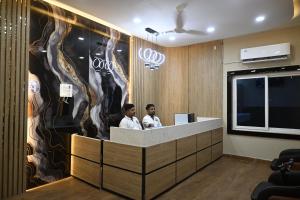 two men standing at a reception desk in a lobby at Hota Residency in Sonepur