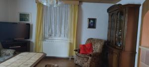 a living room with a tv and a chair with a red pillow at Ferienhaus 2 Bernd in Barth
