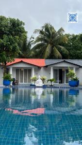 a swimming pool in front of a building with a resort at DD cottages Mandrem Goa in Mandrem