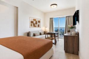 a hotel room with a bed and a desk with a table at Metaxa Hotel Heraklion - Urban Boutique Living in Heraklio