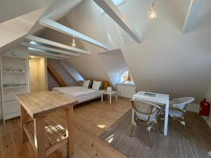 a attic room with a desk and a bed at Købmandsgården, Ballen in Ballen