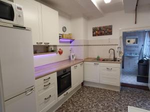 a kitchen with white cabinets and a sink and a microwave at Ferienhaus Max Schmeling in Benneckenstein