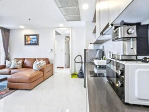 a living room with a couch and a kitchen at Zire WonAmat - Luxury Large One BR Seaview Apartment, Pattay beach in North Pattaya