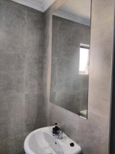 a bathroom with a sink and a mirror at Phumlani Village Lodge in White River +6 photos