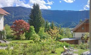 a view of a garden with mountains in the background at Pension & Apartments Weissbriach in Weissbriach