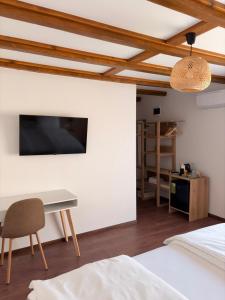 a bedroom with a desk and a tv on a wall at Братановите Къщи in Dŭbravka