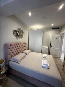 a bedroom with a large bed with a large headboard at Ajsel Luxury Rooms in Sarandë