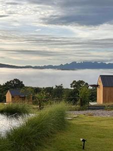 a view of a foggy field with houses and mountains at Hillbilly Farm in Ban Kok Kabok